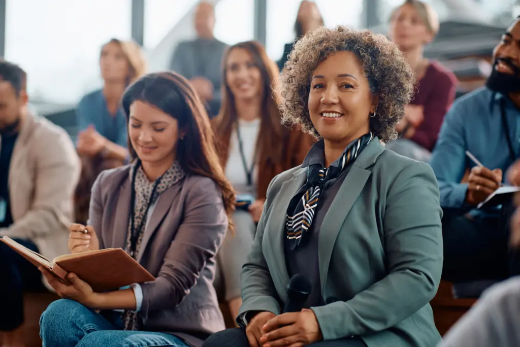 Mature female manager participating in business seminar in conference hall